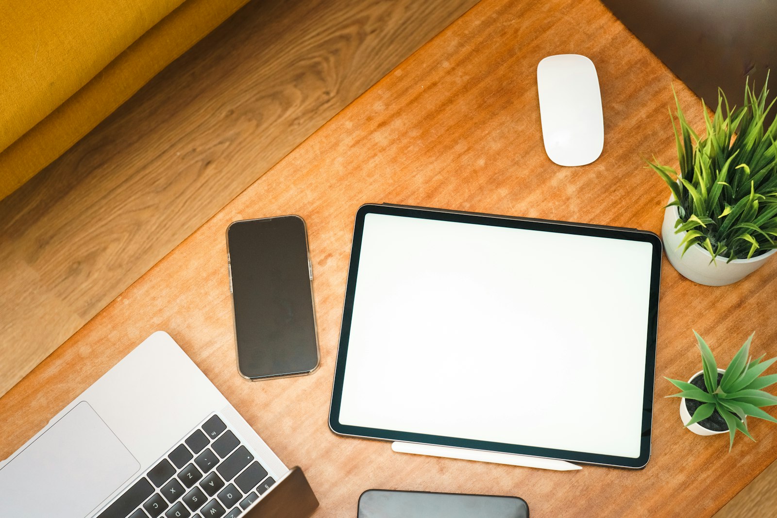 Desk with a laptop, tablet and phone laid out for comparison
